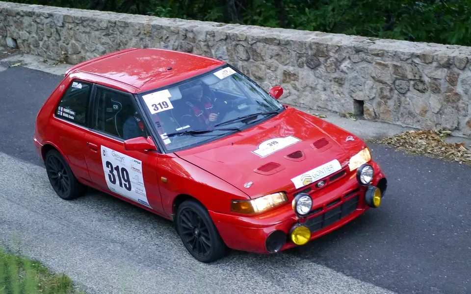 Mazda 323 GTR rouge en épreuve de rallye, photographie du modèle